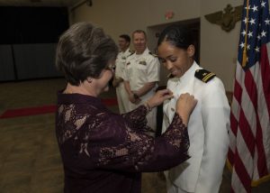 KINGSVILLE, Texas (July 31, 2020) Lt. j.g. Madeline Swegle receives her naval aviator Wings of Gold from her friend Barbara Dodson during a ceremony aboard Naval Air Station Kingsville. Swegle is the U.S. Navy's first Black female tactical jet pilot and will proceed to graduate-level flight training with the "Vikings" of Electronic Attack Squadron 129 at NAS Whidbey Island, Washington, where she wil fly the EA-18G Growler. (U.S. Navy photo by Anne Owens/Released)